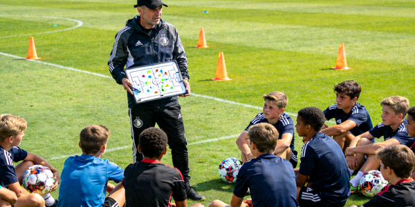 足球教练在训练场上指导年轻球员进行战术演练